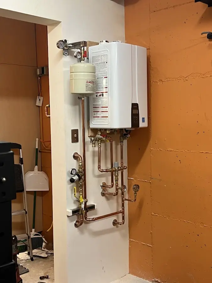 Plumbing technician inspecting water heater connections in Murraysville